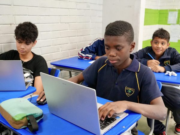 Estudiantes trabajando con computadores en la sala de computación