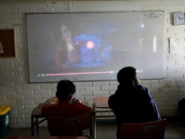 Estudiantes viendo una proyección en la sala oscurecida